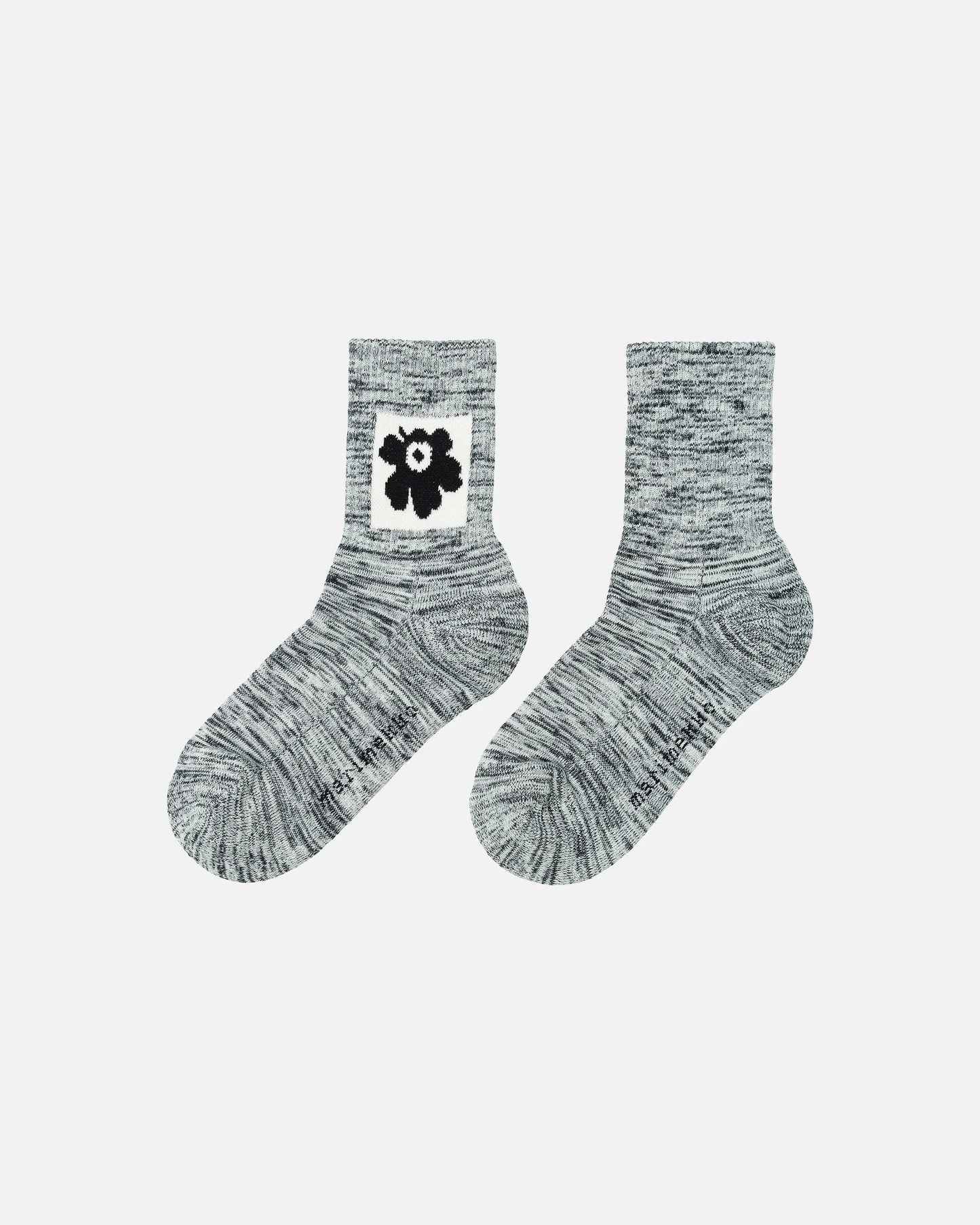Pair of gray melange Marimekko socks with a black and white unikko flower design on a light gray background